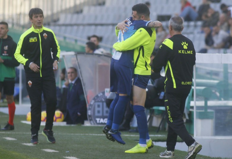 El entrando del Elche Pacheta observa la celebración de dos de sus jugadores / LFP