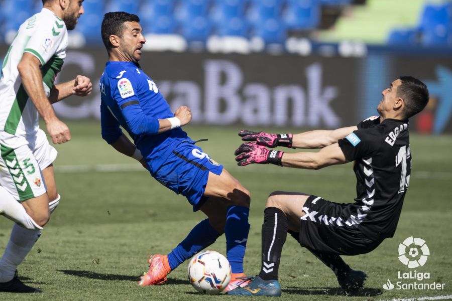 El jugador del Getafe, Ángel Rodríguez, choca con el portero del Elche, Edgar Badía / LaLiga