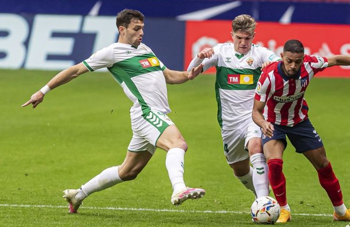 Los jugadores del Elche, Raúl Guti y Boyé, ante Lemar en un partido frente al Atlético / LaLiga